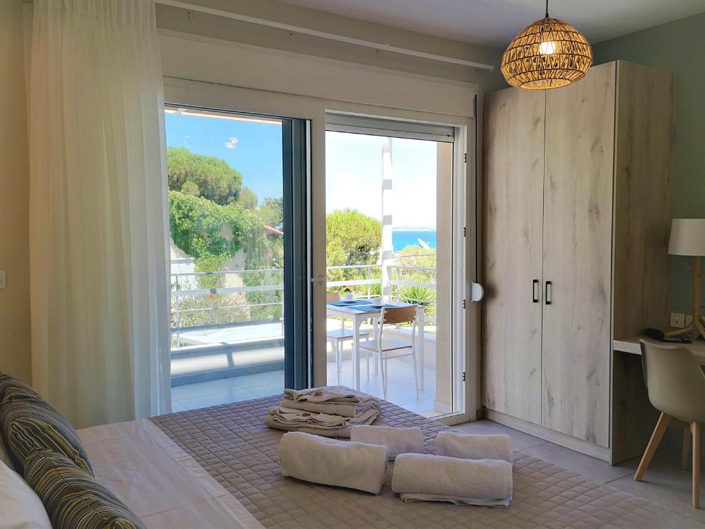 sypialnia z łóżkiem i dużymi szklanymi drzwiami w obiekcie Iris Studios Chios w mieście Karfas