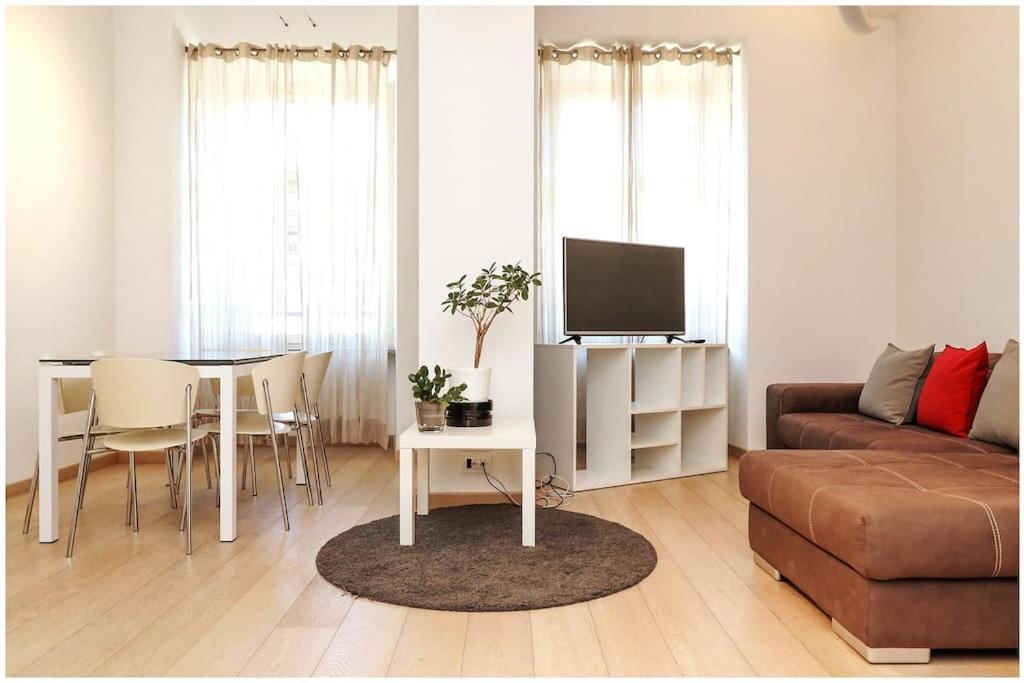 ein Wohnzimmer mit einem Sofa und einem Tisch mit einem TV in der Unterkunft Casa San Carlo nel cuore di Torino in Turin