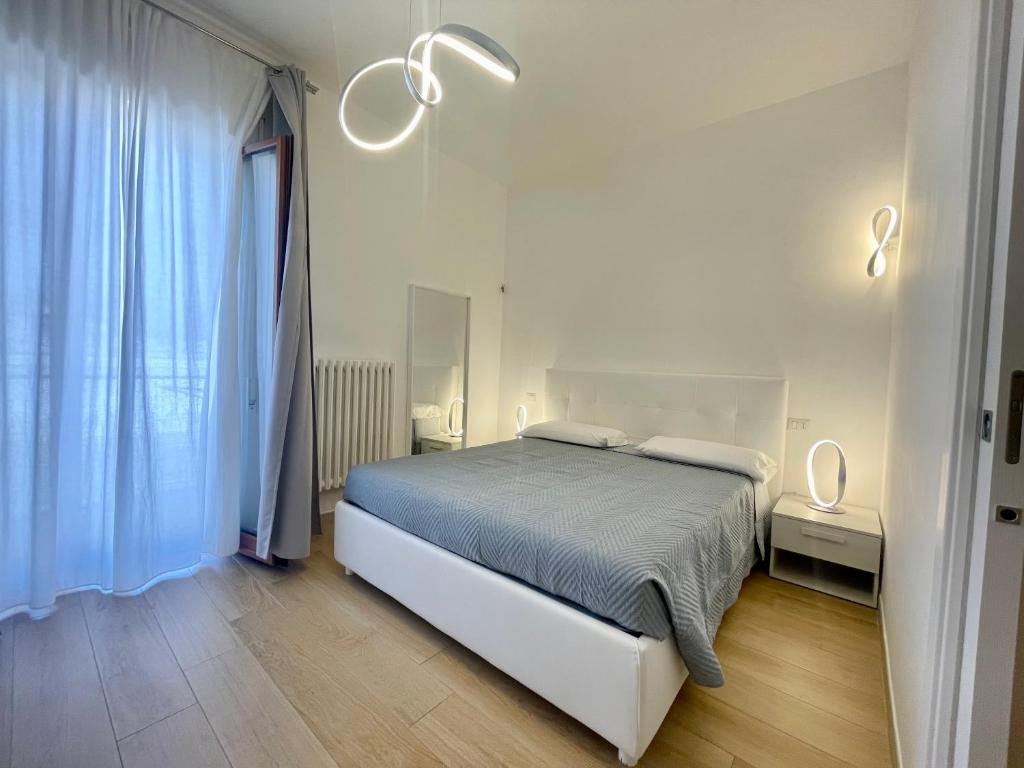 Un dormitorio blanco con una cama y una ventana. en B&amp;B Home Sweet Home - Affitti Brevi Italia, en Manfredonia