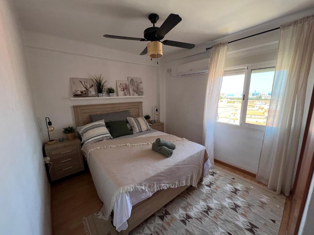 een slaapkamer met een bed en een plafondventilator bij 3 Bedrooms Apt WITH THE SEA VIEW in Málaga