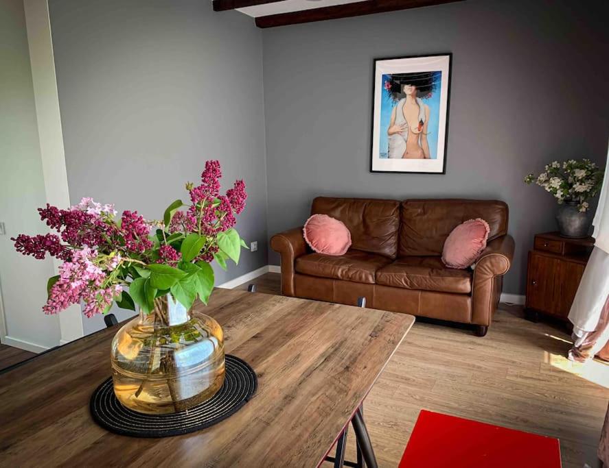 una sala de estar con un jarrón de flores sobre una mesa en Lovely Tiny House en Kelmė