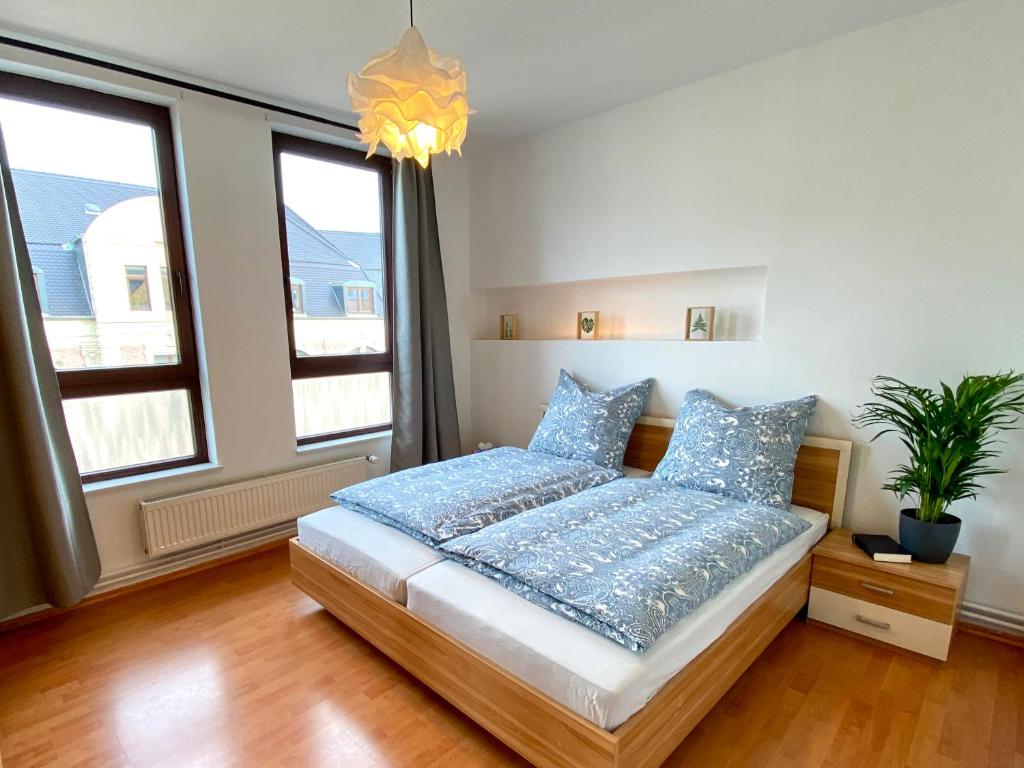 a bedroom with a bed with blue pillows at Bötchen - modern, zentral, für TreppensteigerInnen in Bremerhaven