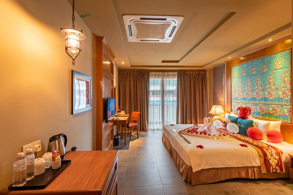 a hotel room with a large bed and a desk at Tasik Villa International Resort in Port Dickson