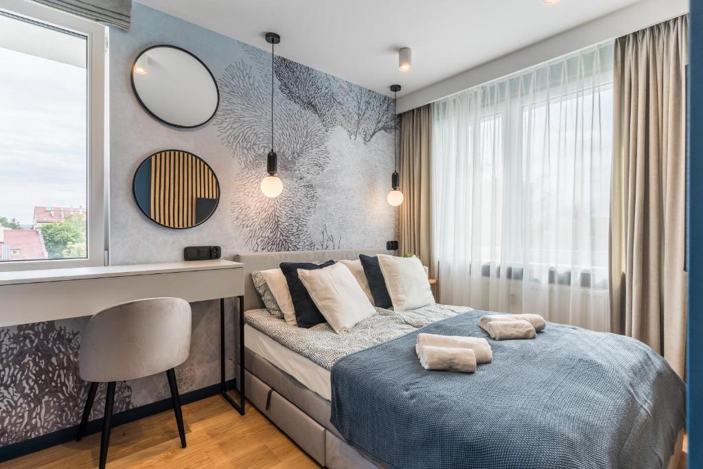 a bedroom with a bed and a desk and a window at Golden Seaside Beach - 200m from the sea in Gdańsk