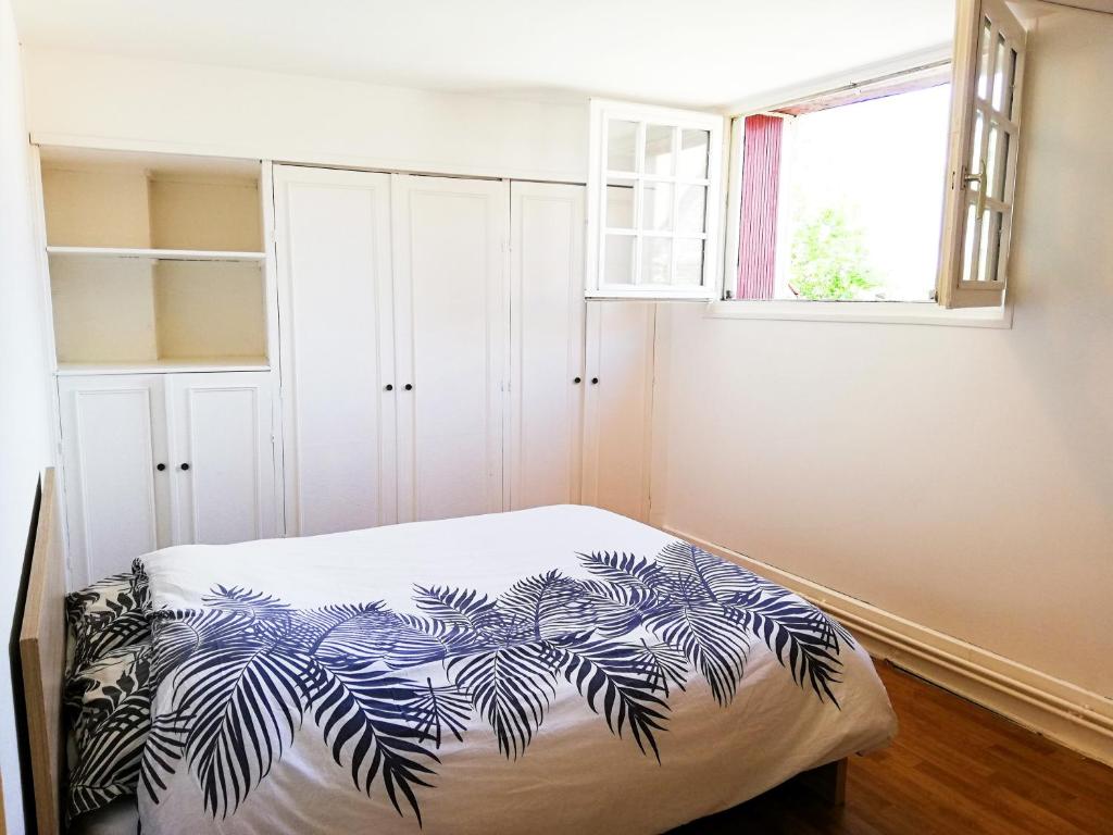 a bedroom with a bed with a blue and white blanket at L'ancien relai de poste de Magny-Cours in Magny-Cours