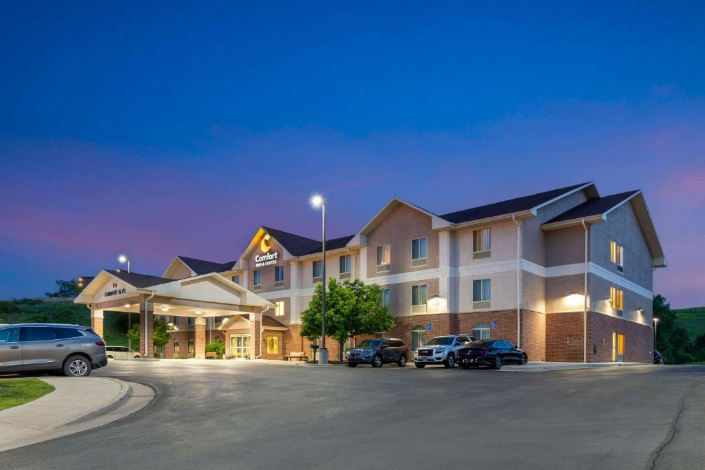 un gran edificio con coches estacionados en un estacionamiento en Comfort Inn & Suites, en Rapid City