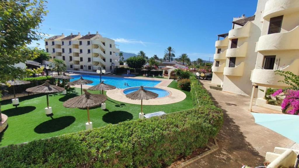 una vista aérea de un complejo con piscina y sombrillas en Acogedor apartamento en la Playa. Urbanización La Felicidad. Las Marinas en Dénia