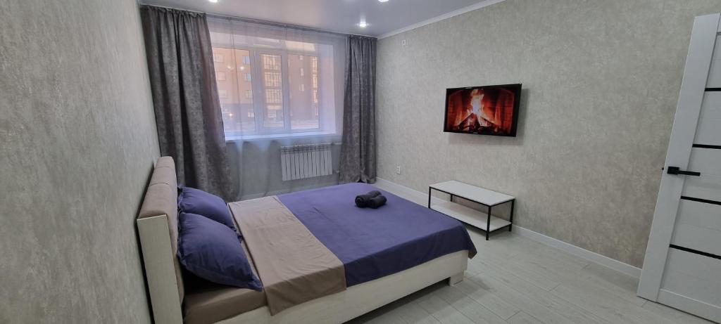 um quarto com uma cama e uma janela em Однокомнатная квартира в районе ЖК Аружан em Kokshetau