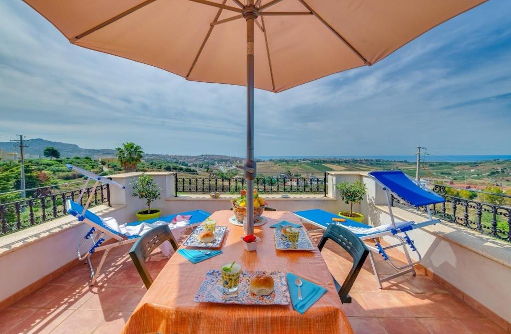 a patio with a table and chairs and an umbrella at La Rosa Rossa in Sciacca