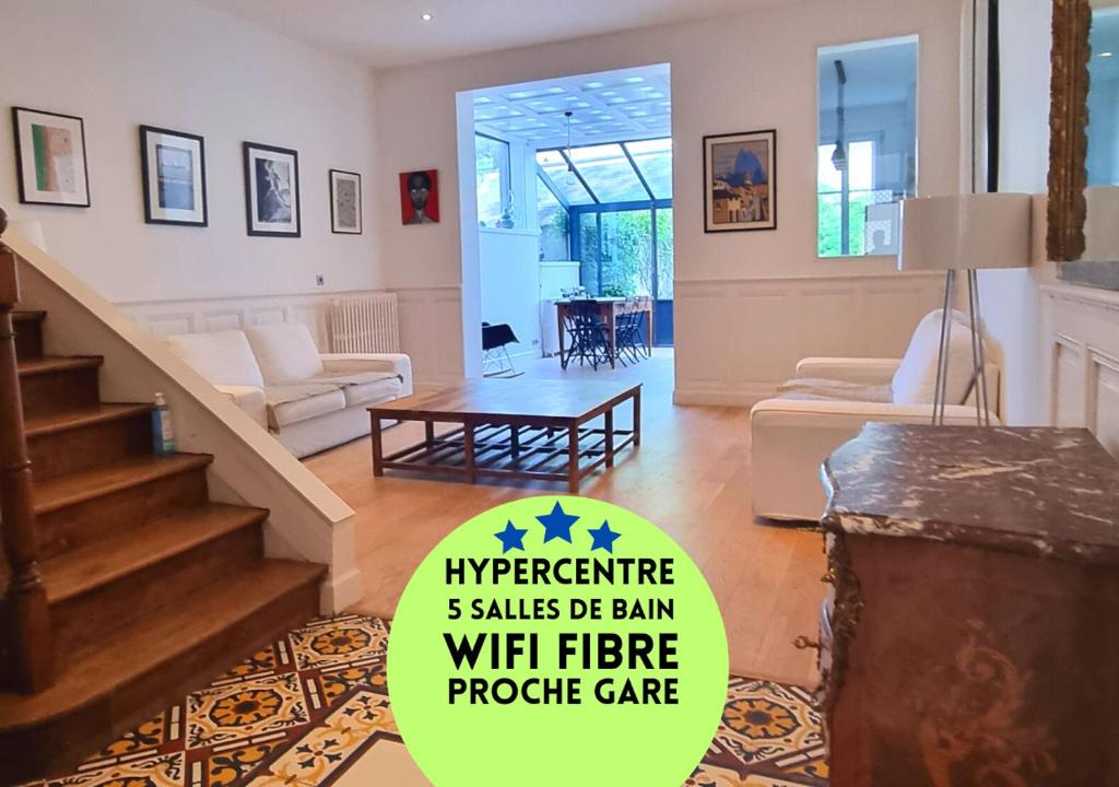 a living room with a staircase and a living room with a table at "Demeure de Charme" Hyper Centre - 6 chambres - 11 voyageurs - Châteaux de la Loire in Tours