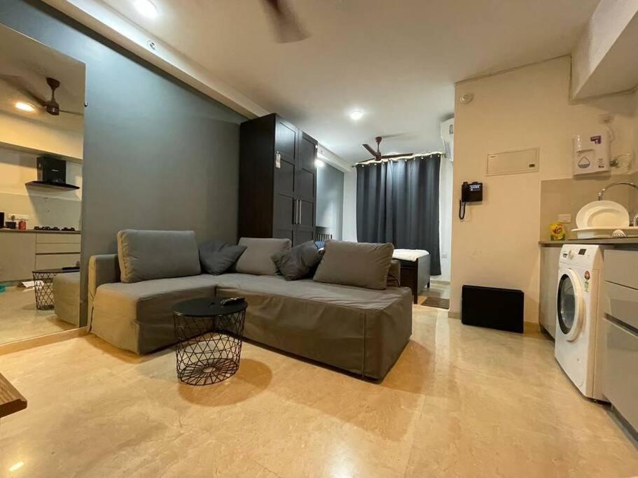 ein Wohnzimmer mit einem Sofa und einer Küche in der Unterkunft Elegantly designed Studio Apt in Thane