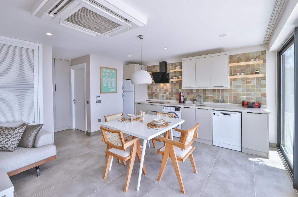 a kitchen and dining room with a white table and chairs at Born in Blue in Kaş