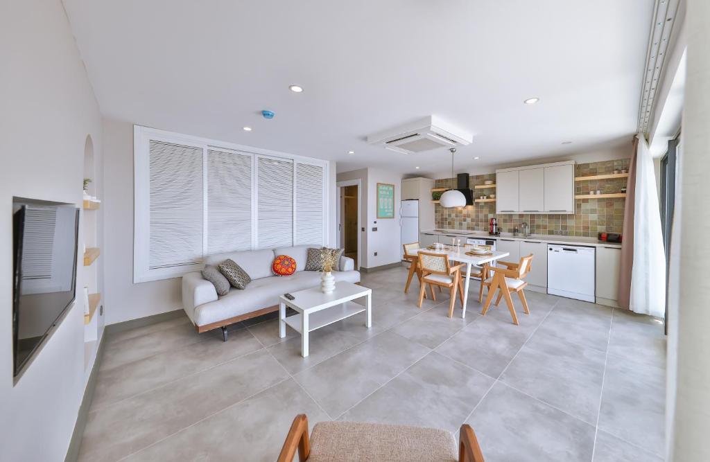 a living room and kitchen with a couch and a table at Born in Blue in Kaş