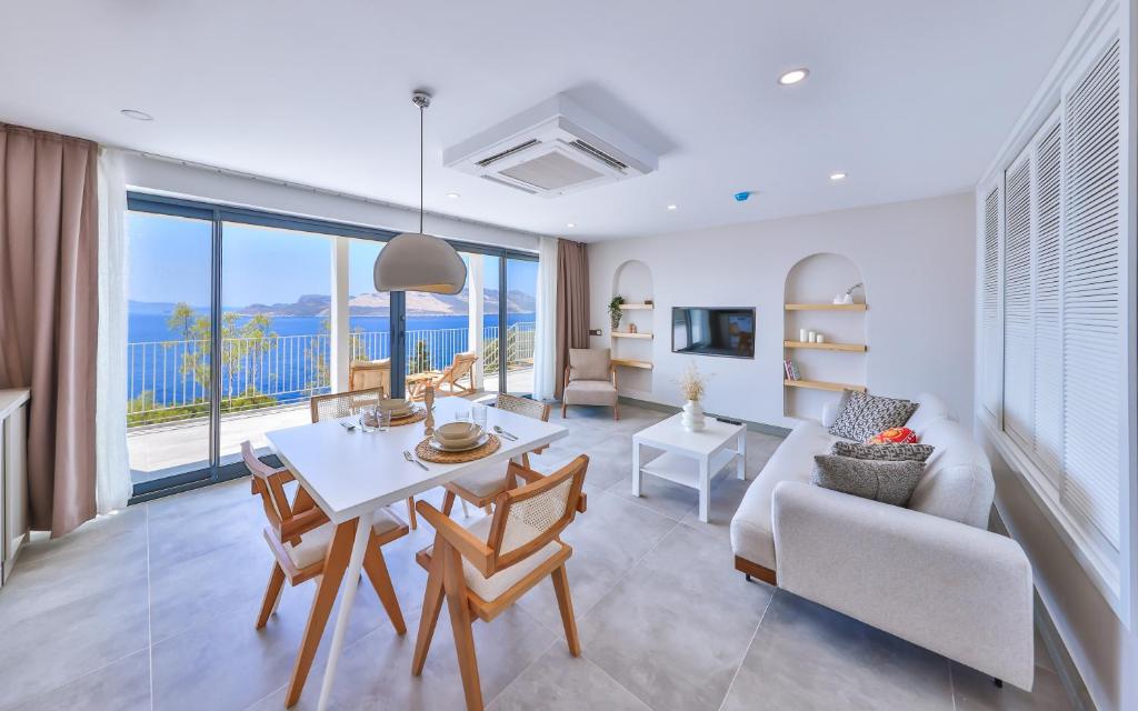 a living room with a table and chairs and a large window at Born in Blue in Kaş