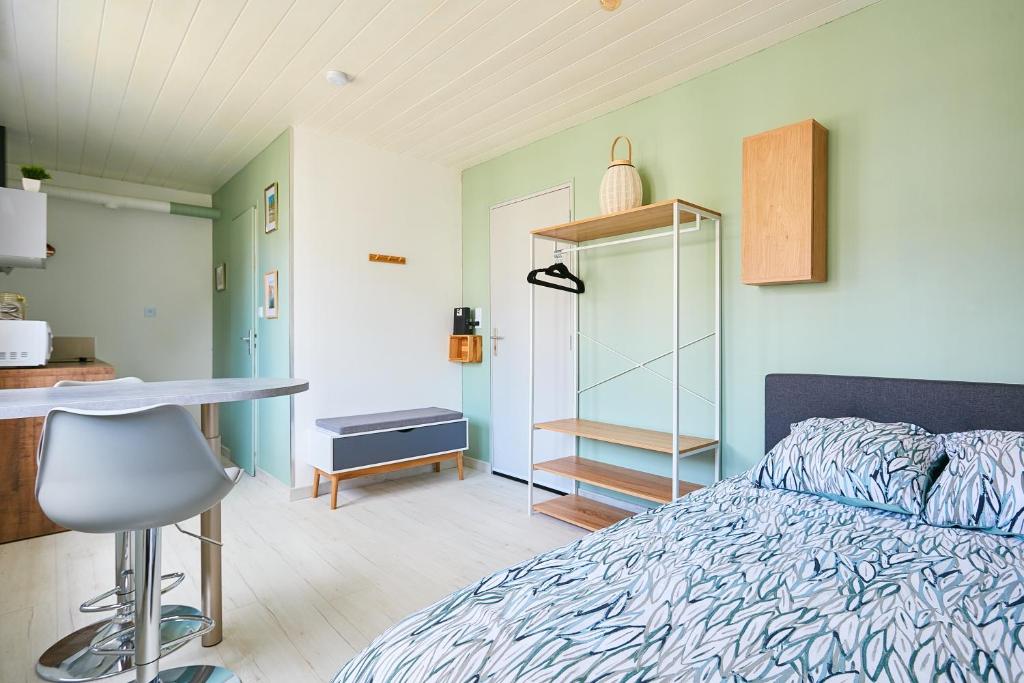 a bedroom with a bed and a desk and a table at L'appartement in Pontarlier