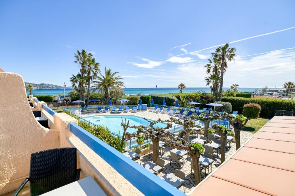 サント・マキシムにあるHôtel La Nartelleのリゾートのプールの景色を望めます。