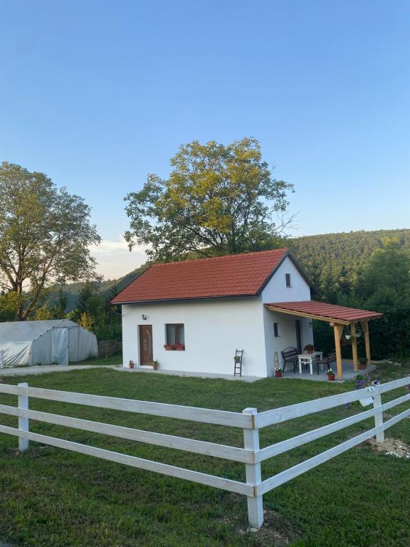 a white house with a fence in front of it at Hill House Emir in Bihać