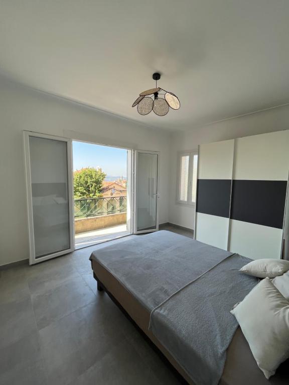 a bedroom with a large bed and a large window at Villa 2 chambres rénovée Juillet 2023 - vue mer - parking privé in Grasse