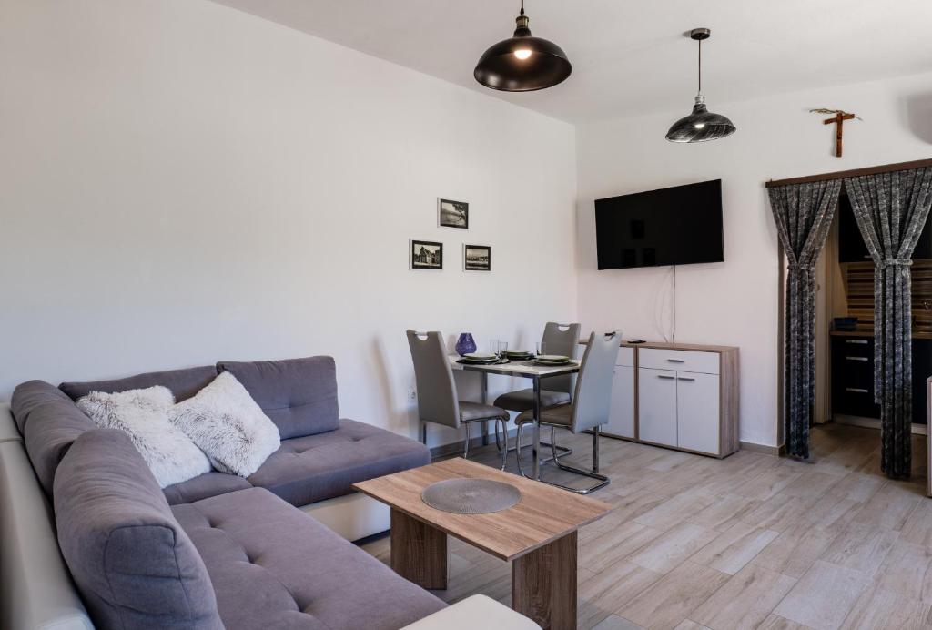 a living room with a couch and a table at Apartman Tonči Bruno - obnovljen 2026 sa novim dvorištem in Pag