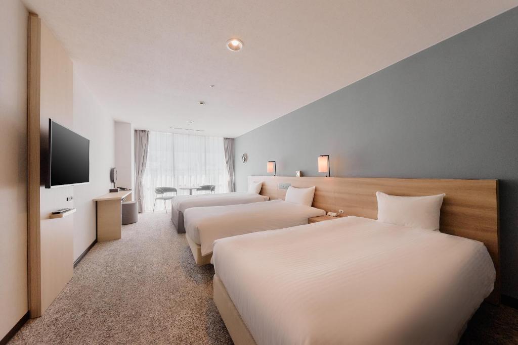 a hotel room with two beds and a flat screen tv at Kyoto Tower Hotel in Kyoto
