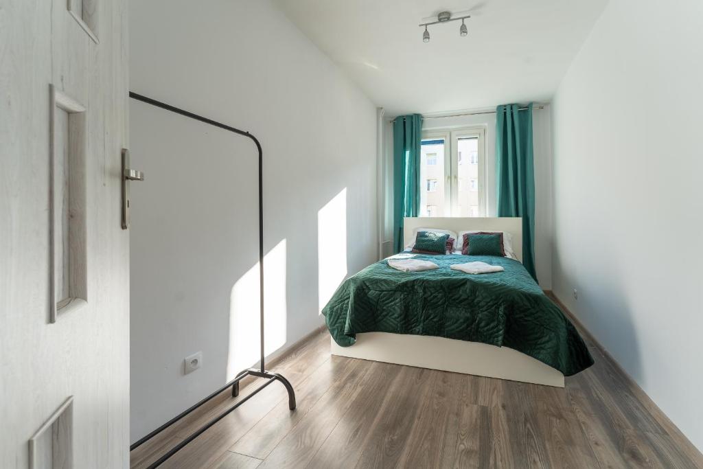 a bedroom with a bed with a green blanket at Tanie Spanie Skowronek - Pet Friendly - przytulny 4 osobowy - Space Apart in Jelenia Góra