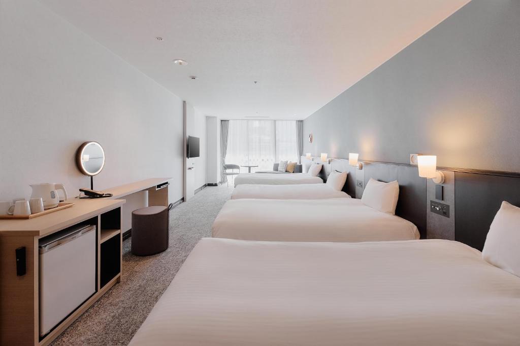a row of beds in a hotel room at Kyoto Tower Hotel in Kyoto