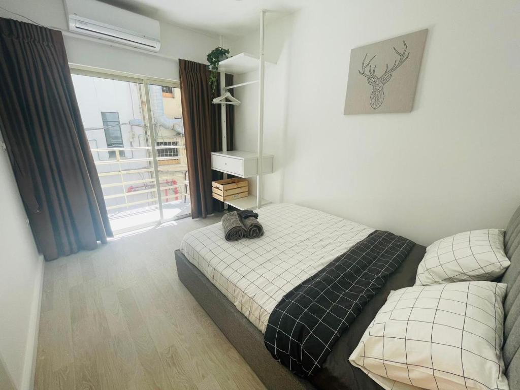 a bedroom with a bed and a window at Haneemanim Apartments in Haifa