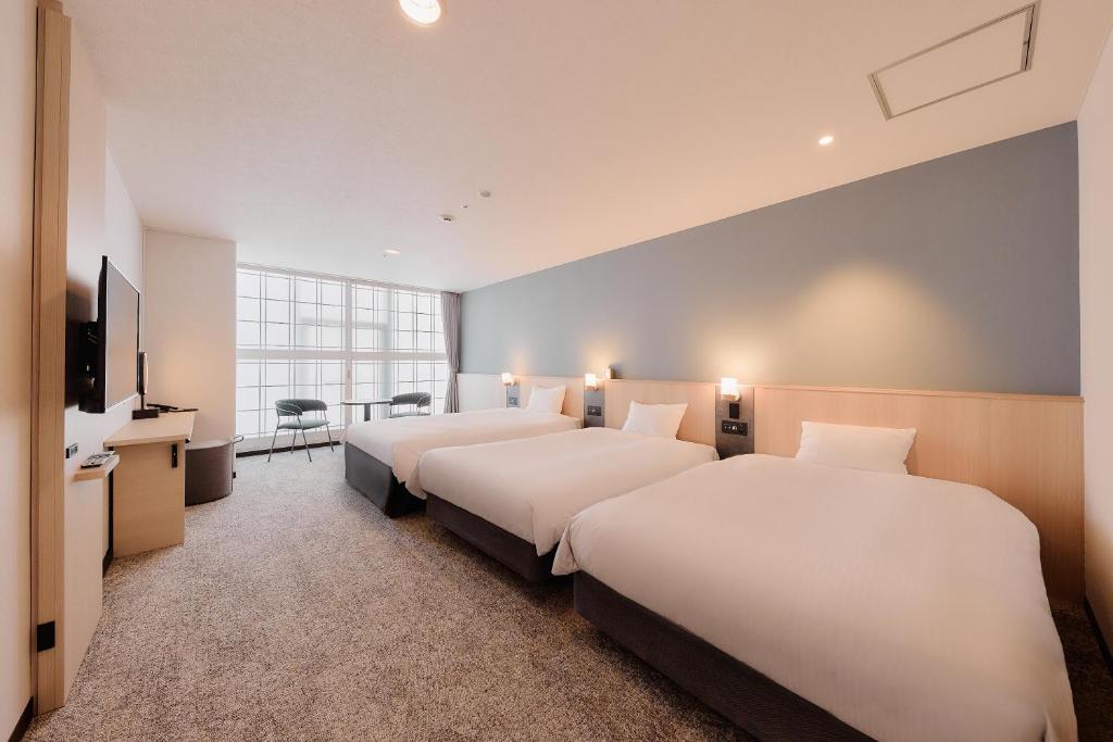 a hotel room with two beds and a television at Kyoto Tower Hotel in Kyoto