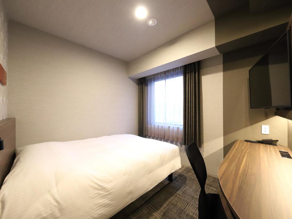 Postel nebo postele na pokoji v ubytování Smile Hotel Kanazawa Nishiguchi Ekimae