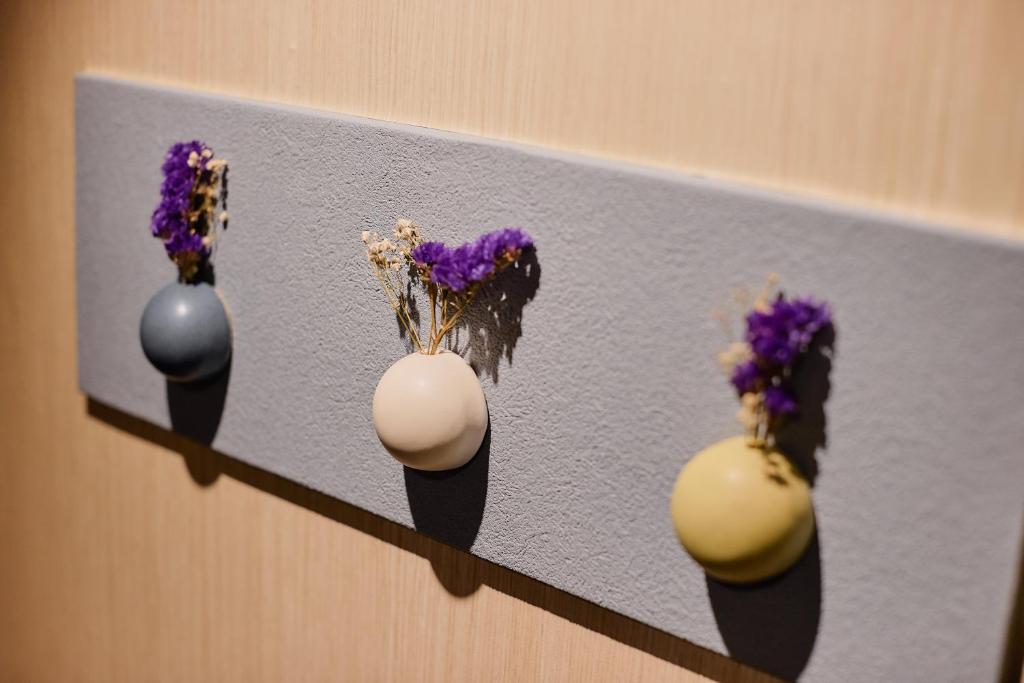 a row of vases with flowers in them on a shelf at Kyoto Tower Hotel in Kyoto