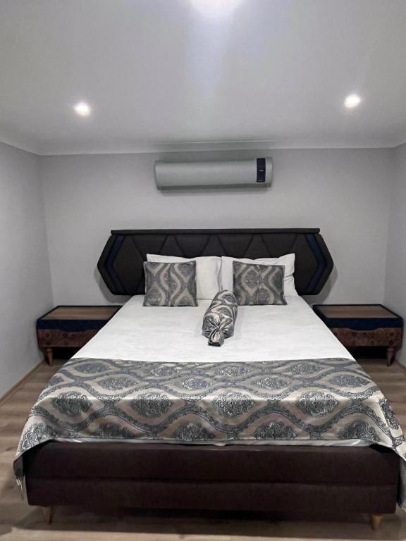 1 dormitorio con 1 cama grande con sábanas y almohadas blancas en Bayraktar apart, en Pelitli