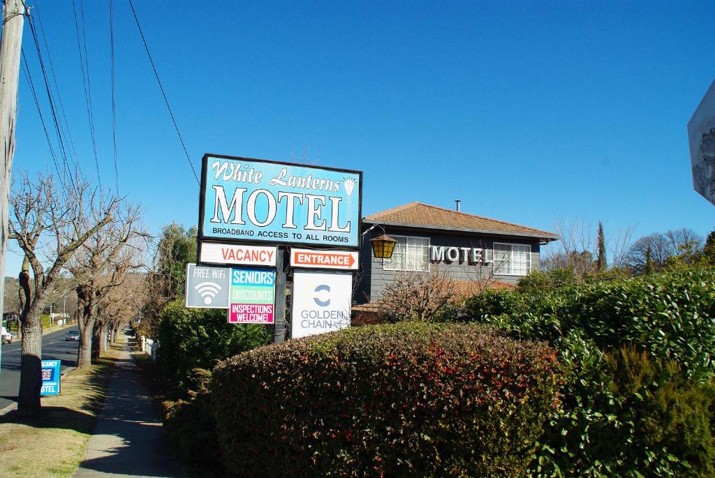 um sinal de motel em frente a uma casa em White Lanterns Motel em Armidale