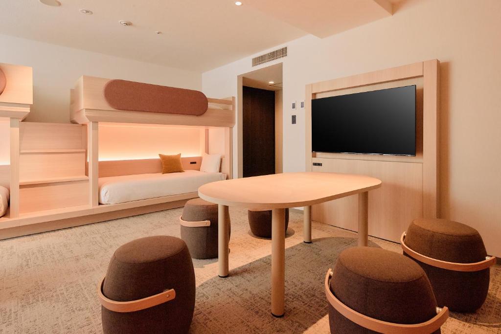 a bedroom with a bunk bed and a table and stools at Kyoto Tower Hotel in Kyoto
