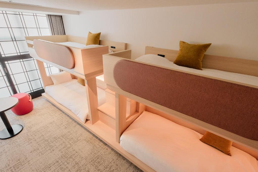 a room with two bunk beds and a stool at Kyoto Tower Hotel in Kyoto