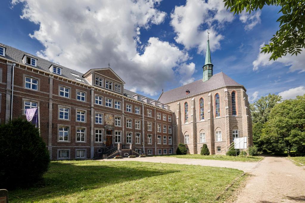 a large brick building with a steeple on top of it at SEPHS Hotel in Sittard