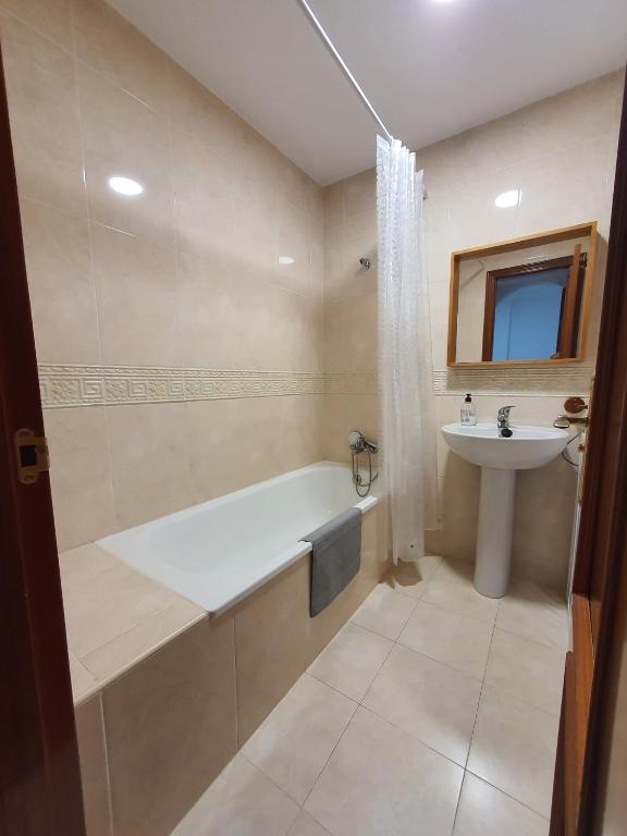 a bathroom with a bath tub and a sink at Apartamento PUERTO in Mazagón