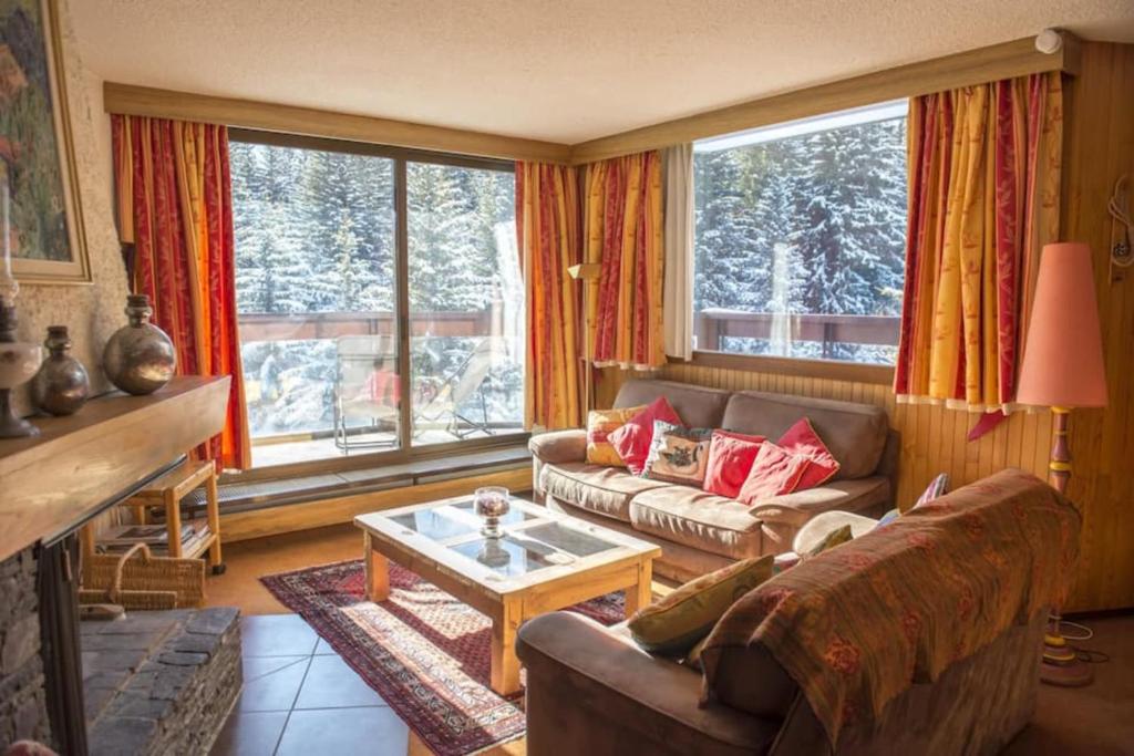 a living room with a couch and a table at Luxury apartment near the slopes in Courchevel in Courchevel