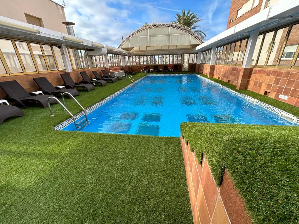 een zwembad in het midden van een gebouw bij Hotel Victoria in Segur de Calafell