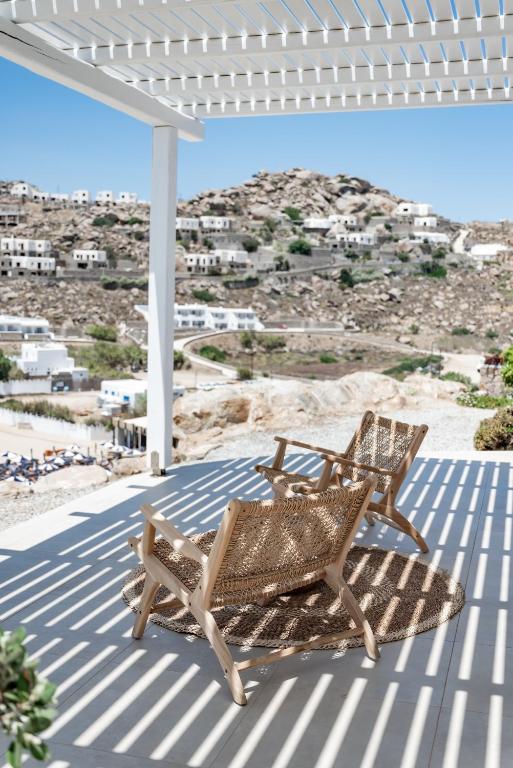two wicker chairs sitting on a patio with a view at Super Paradise Hotel in Super Paradise Beach