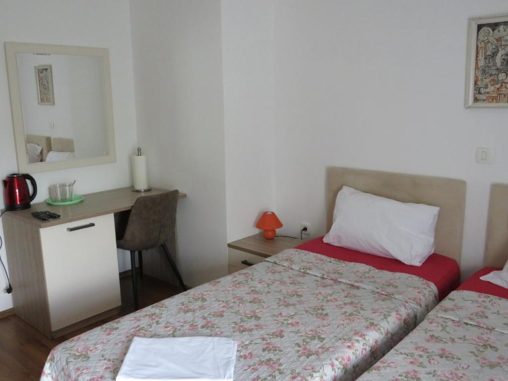 1 dormitorio con 2 camas, escritorio y espejo en Split Apartments Beta, en Split