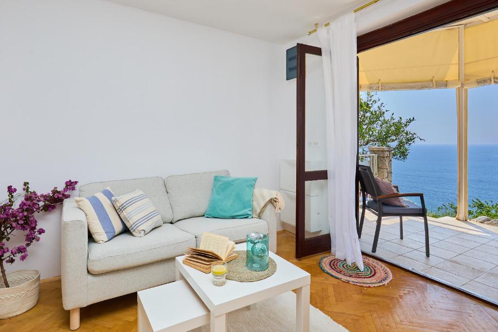 a living room with a couch and a view of the ocean at Sunset Oasis in Dubrovnik