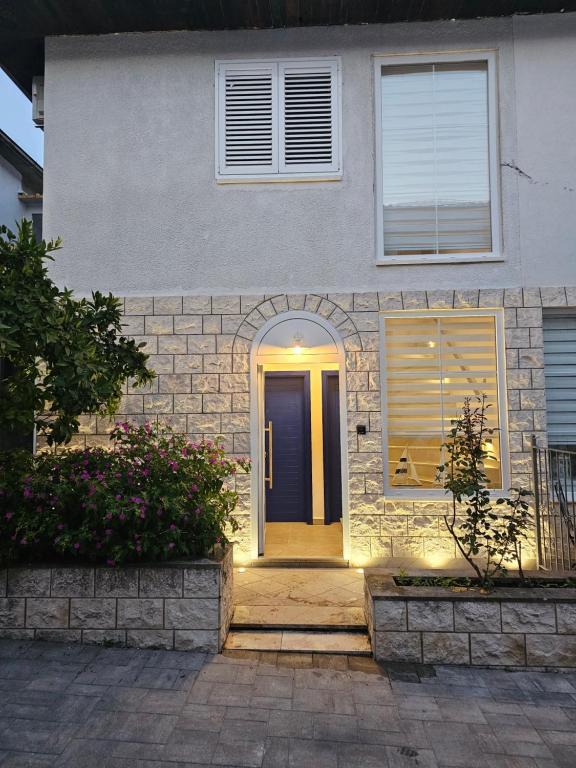 a front door of a house with a blue door at Villa Dardona Drvenik in Drvenik