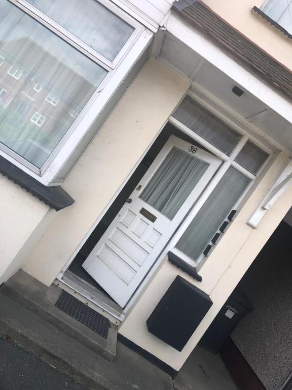 une porte d'entrée d'une maison avec une porte blanche dans l'établissement Ac lounge36 (B), à Rochford