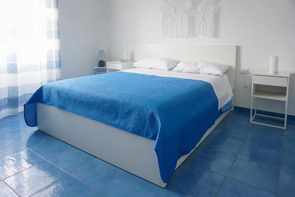 a bedroom with a bed with a blue blanket at Affittacamere Angelica in Bacoli