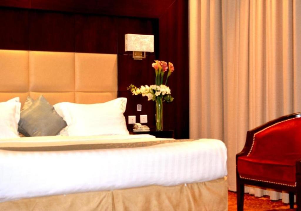 ارجان سويت 2 في جدة: غرفة نوم بسرير و إناء من الزهور