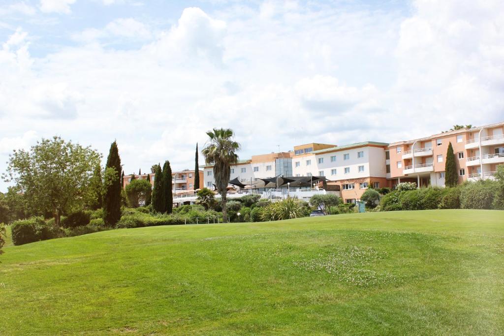 a golf course with a green in front of condos at Hôtel Golf Fontcaude in Montpellier
