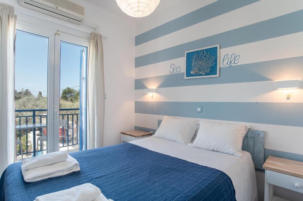 - une chambre avec un lit bleu et un balcon dans l'établissement Livadia Seaside Studios 7, à Parikia