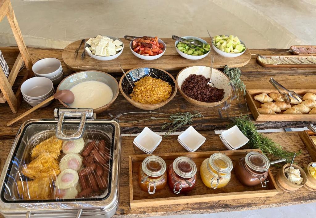 a wooden table topped with lots of different types of food at Le Rêve Boutique Hotel in Dhërmi