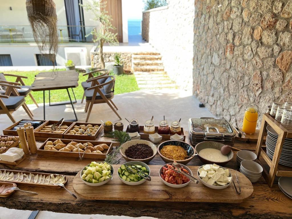 a table with many different dishes of food on it at Le Rêve Boutique Hotel in Dhërmi