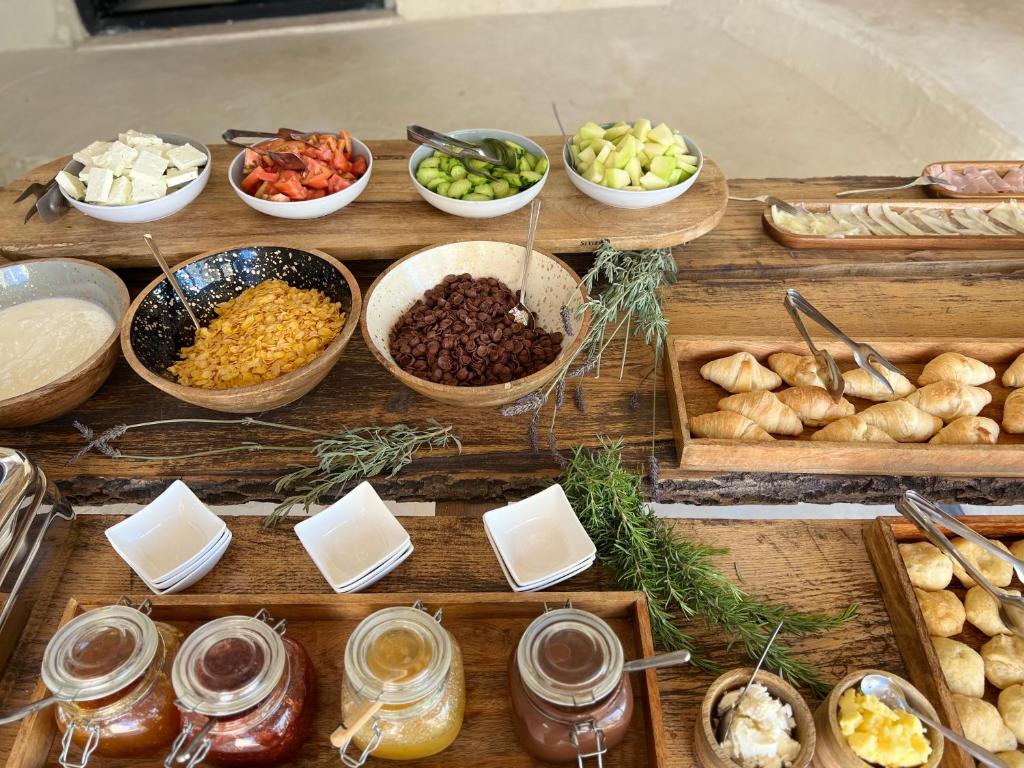 a wooden table with bowls of different types of food at Le Rêve Boutique Hotel in Dhërmi
